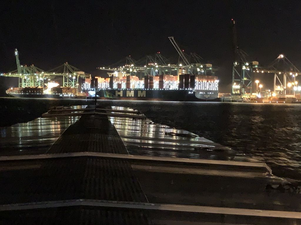 Verlichte containerterminal met zeeschip